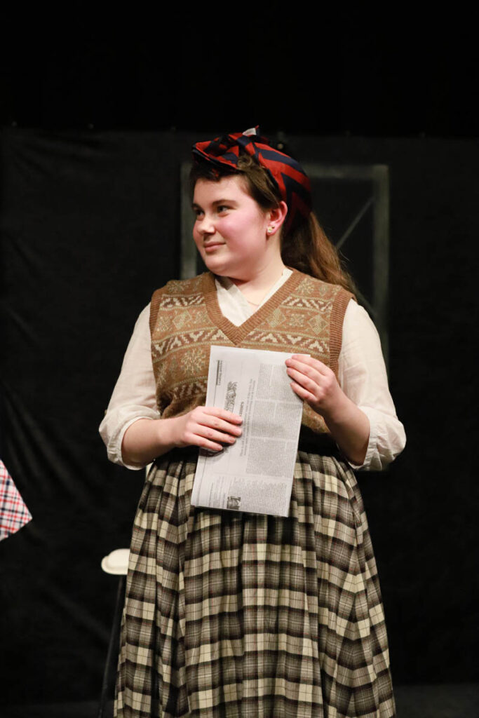 A female student is acting on stage dressed in costume at the HLNSC Ludlow College.
