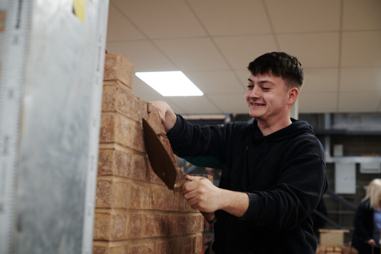 boy learning how to brick lay