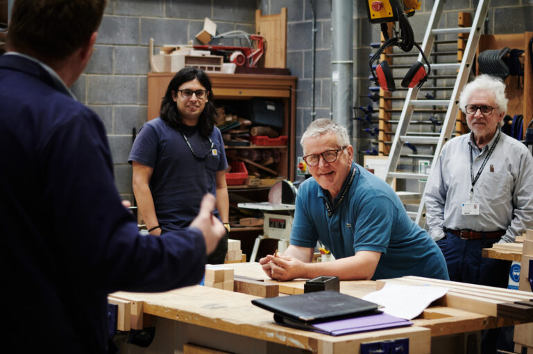 lecturers and students talking in wood work class