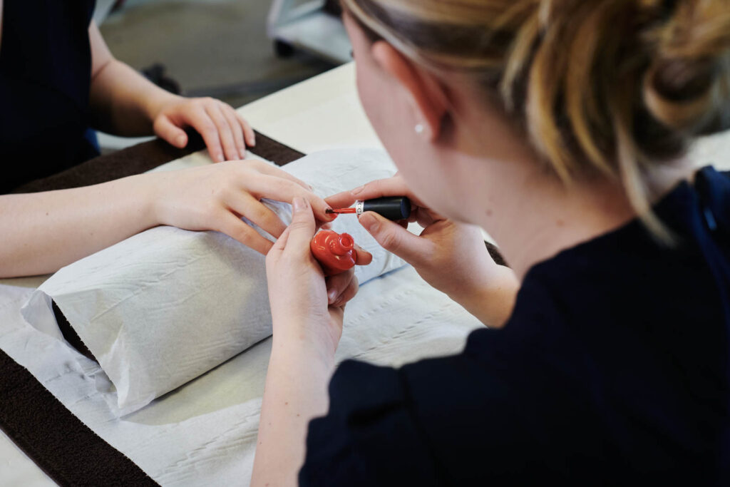 A female beauty student completing a nail treatment at Herefordshire college