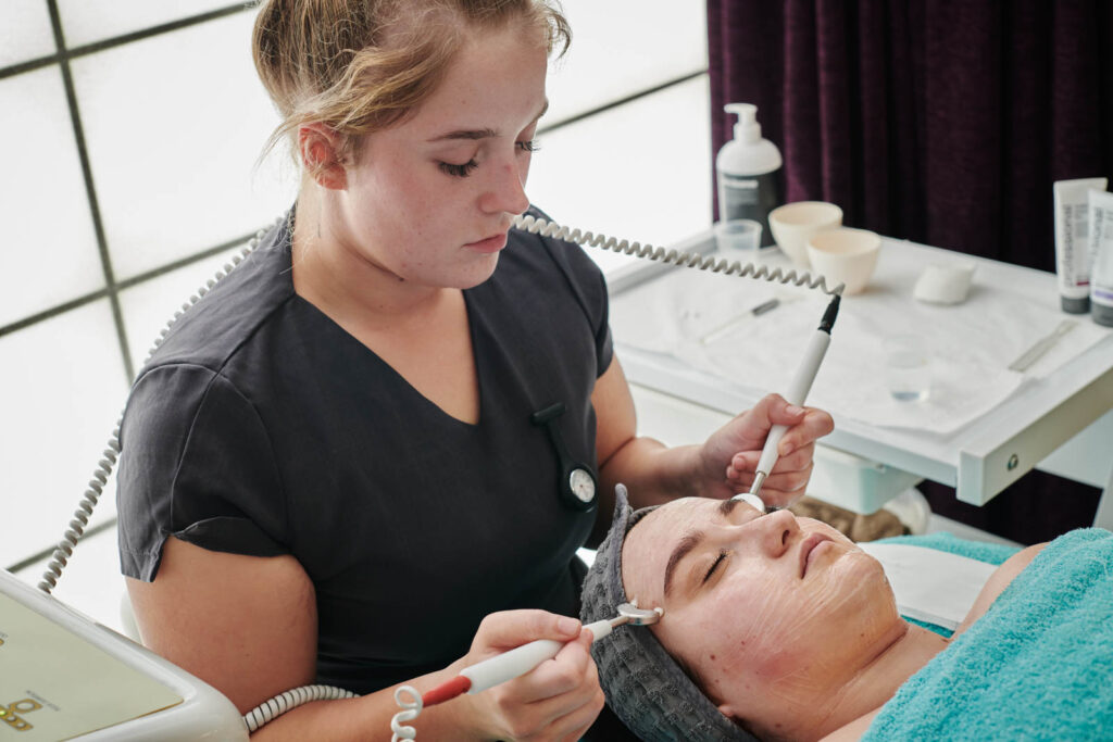 A female beauty student completing a facial treatment at Herefordshire college