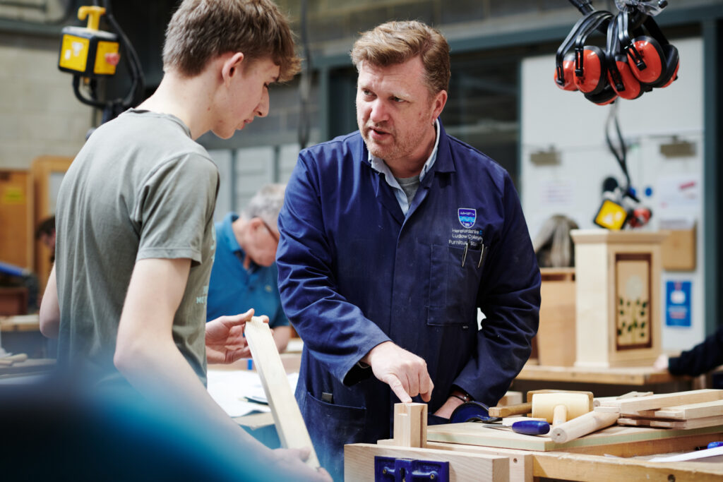 lecturer helping student in carpentry class
