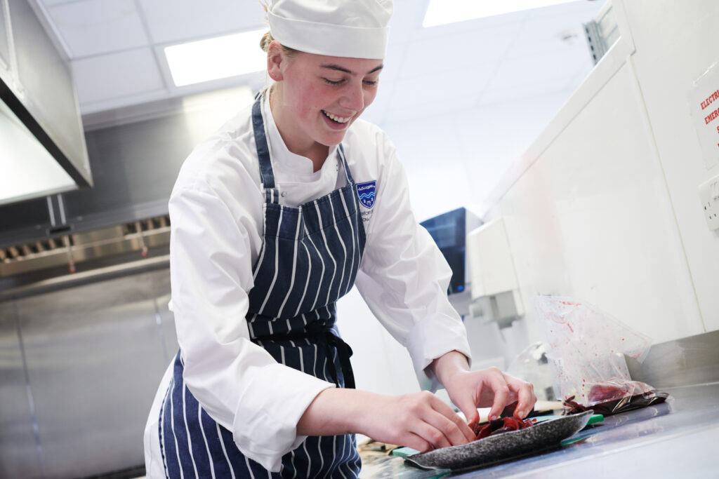 student preparing a plate in a catering class