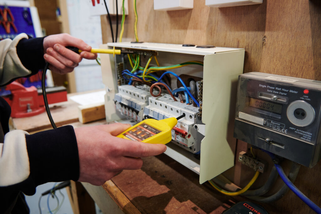 student doing the electric circuit board testing if everything is okay