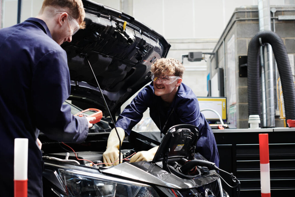 two students working on a car