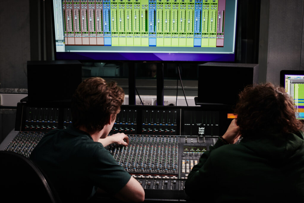 students in the music studio making music on the producers equipment