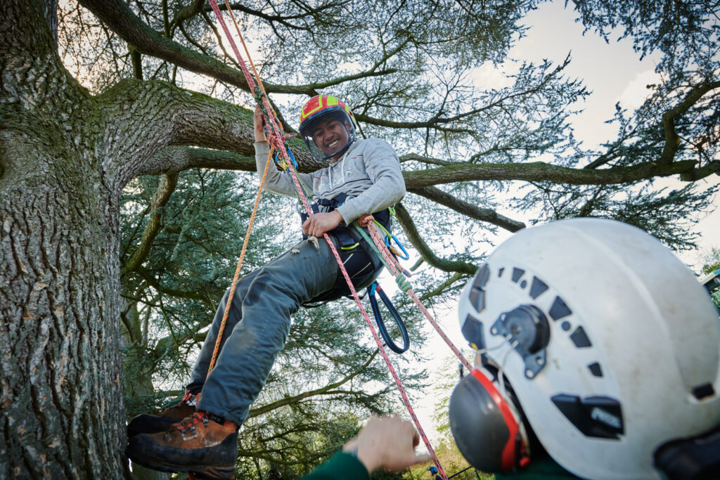 Student being harnessed from a tree