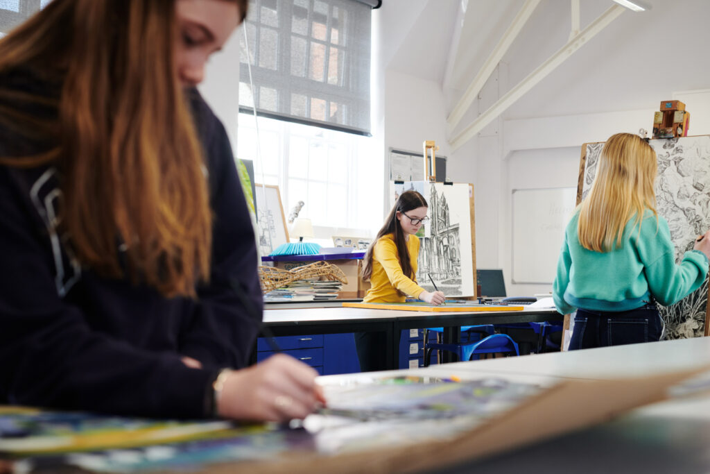 Students painting on canvases in Art class at Ludlow College