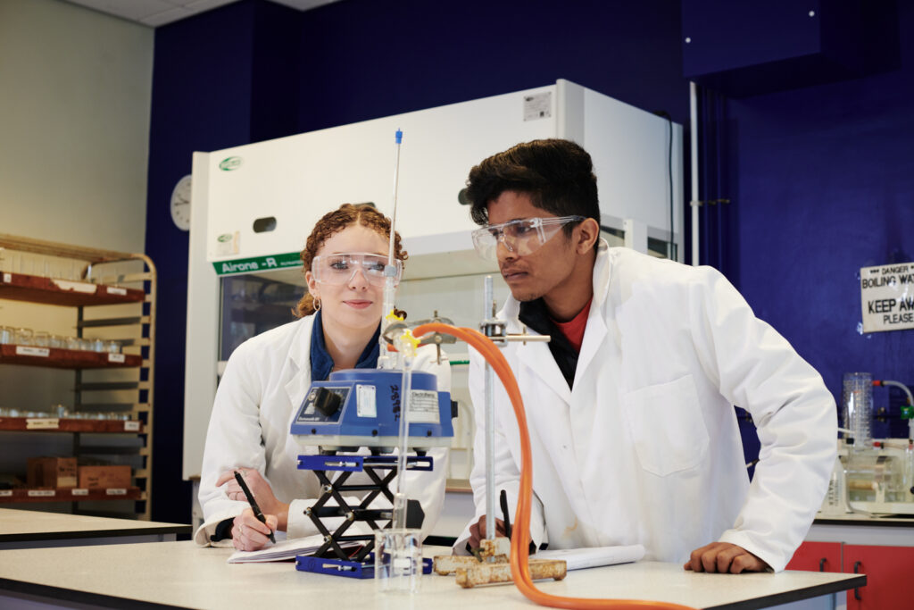 Two students using equipment and technology for an experiment in Chemistry at Ludlow College