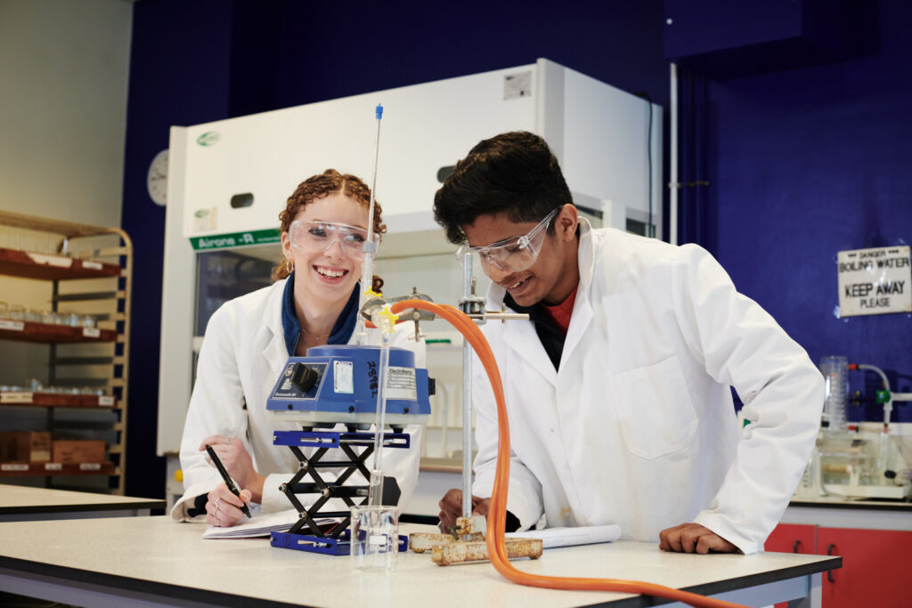 Two students using equipment and technology for an experiment in Chemistry at Ludlow College