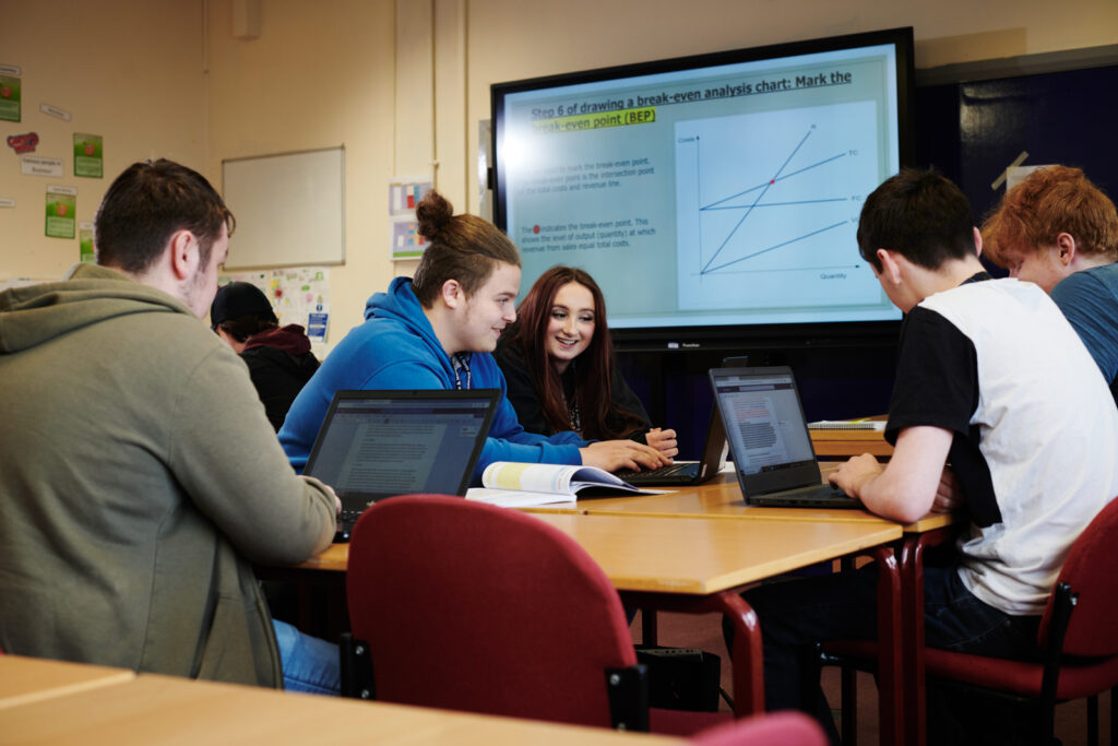 A group of students on their laptops in business class at North Shropshire College