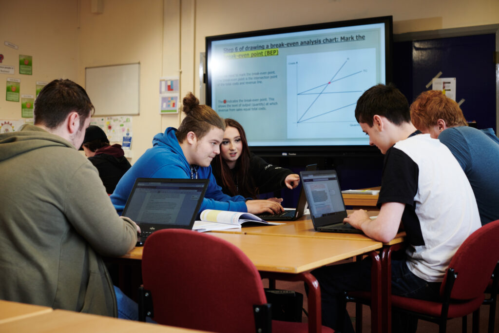 A group of students on their laptops in business class at North Shropshire College