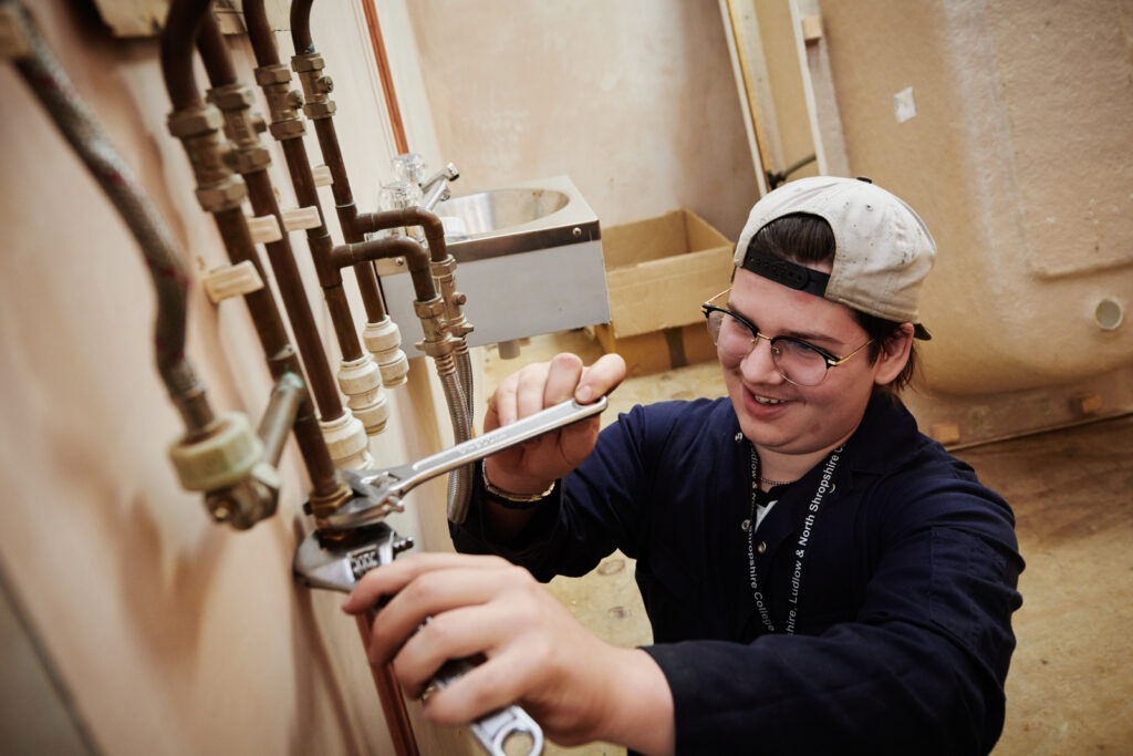 student fixing pipes in the plumbing course