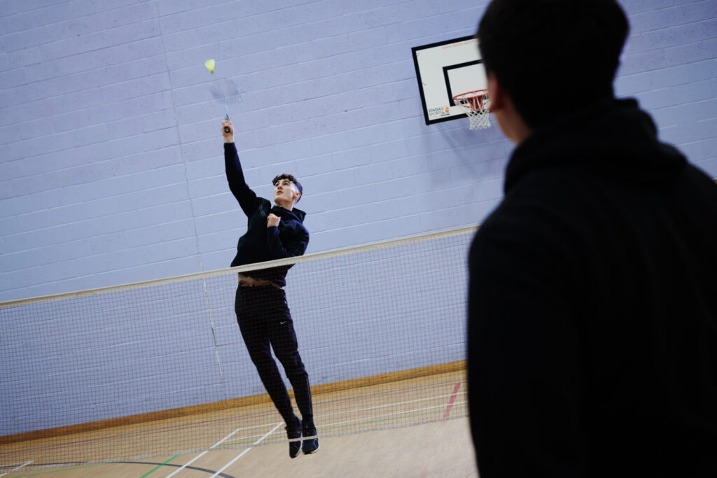 two students playing badminton on the sports course