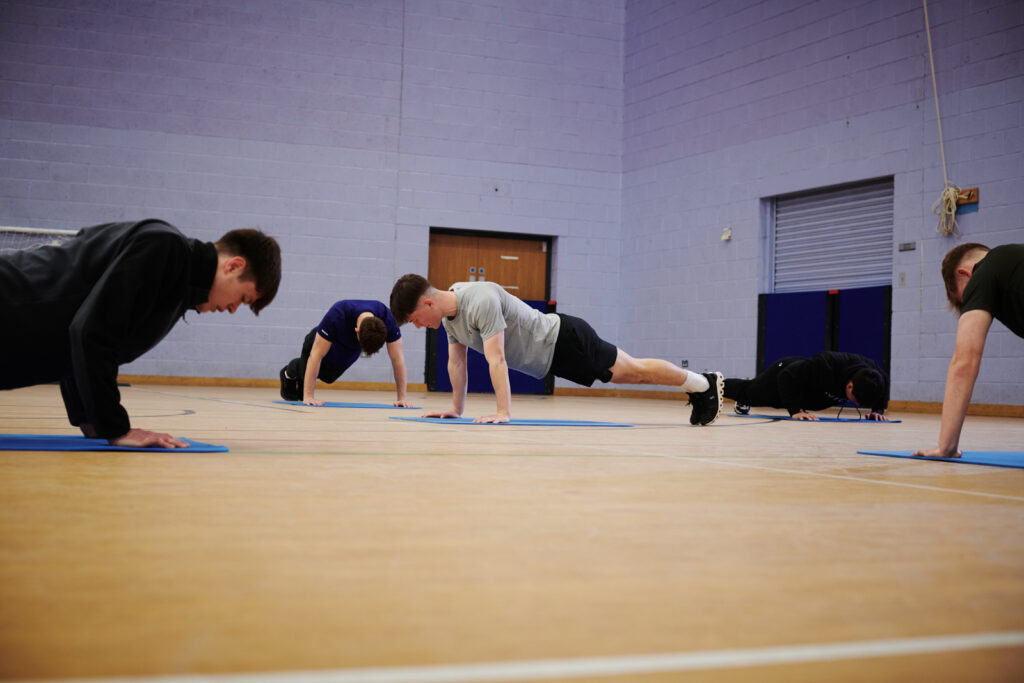 students doing press ups in the gym