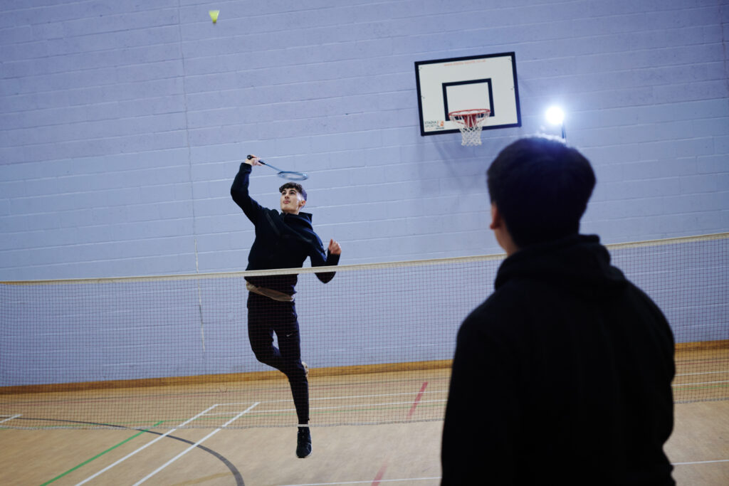 two students playing badminton on the sports course