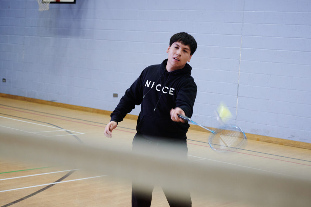 student playing badminton on a sports course
