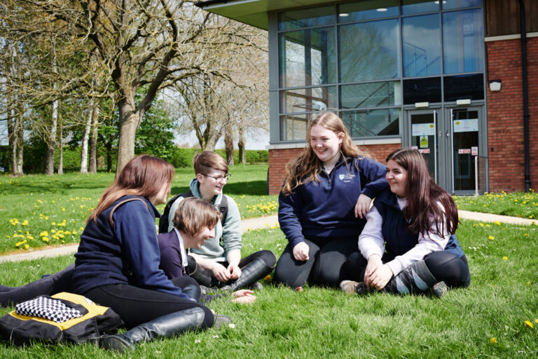 students sat on the grass outside of one of Walford colleges buildings