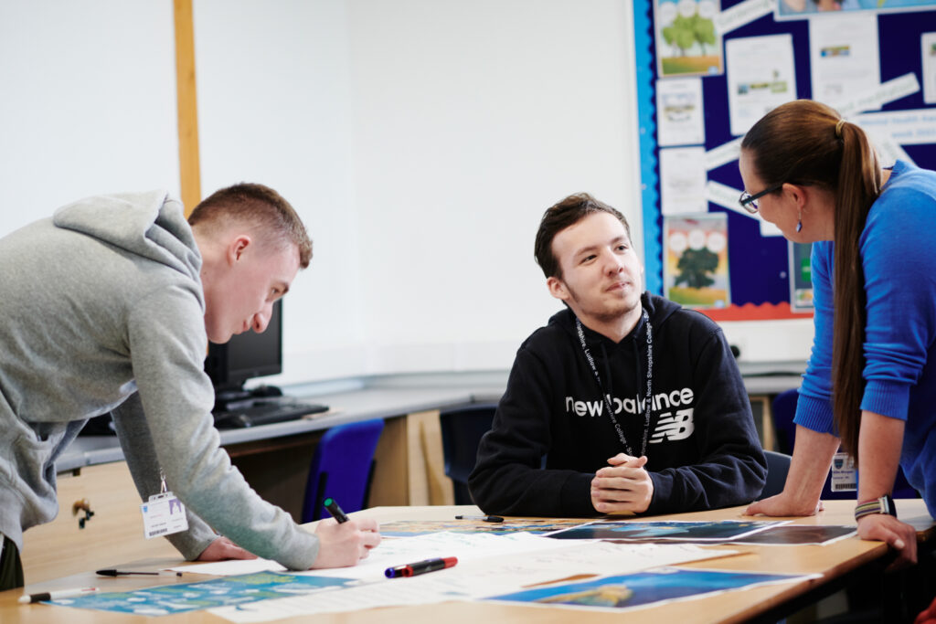 two students and a lecturer discussing the work that they have done in the classroom