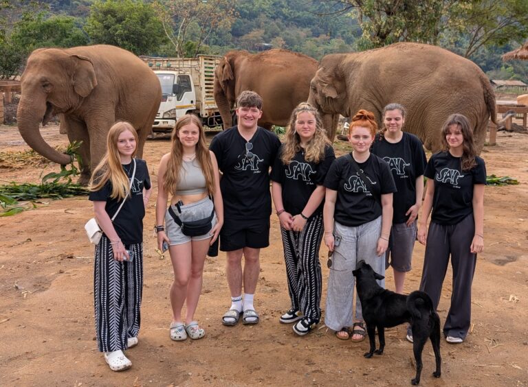 Students with an elephant in the background in Thailand.