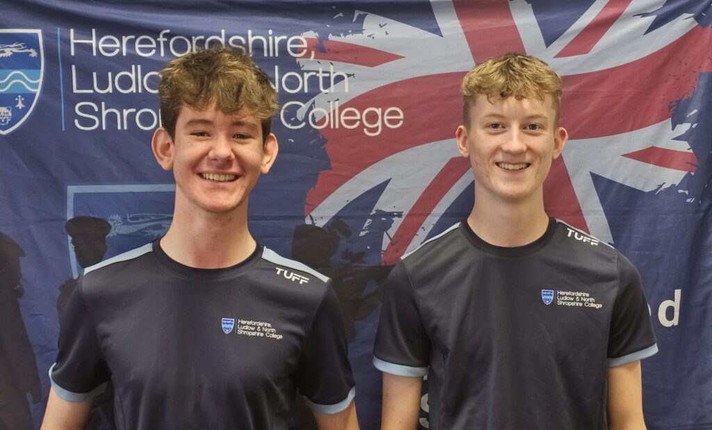 Herefordshire College students standing in front of flag